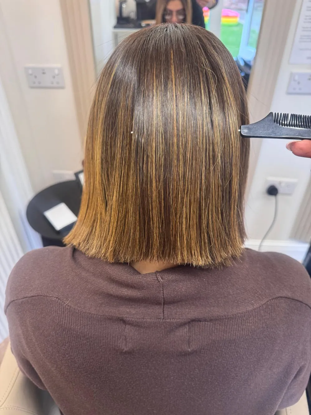 Glossy shoulder-length bob with caramel highlights