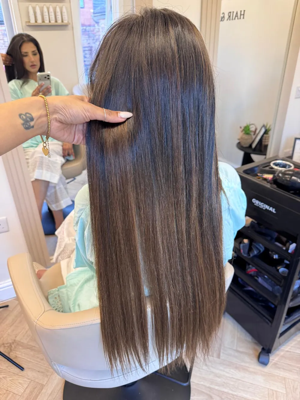 Long, straight brunette hair with tape-in hair extensions