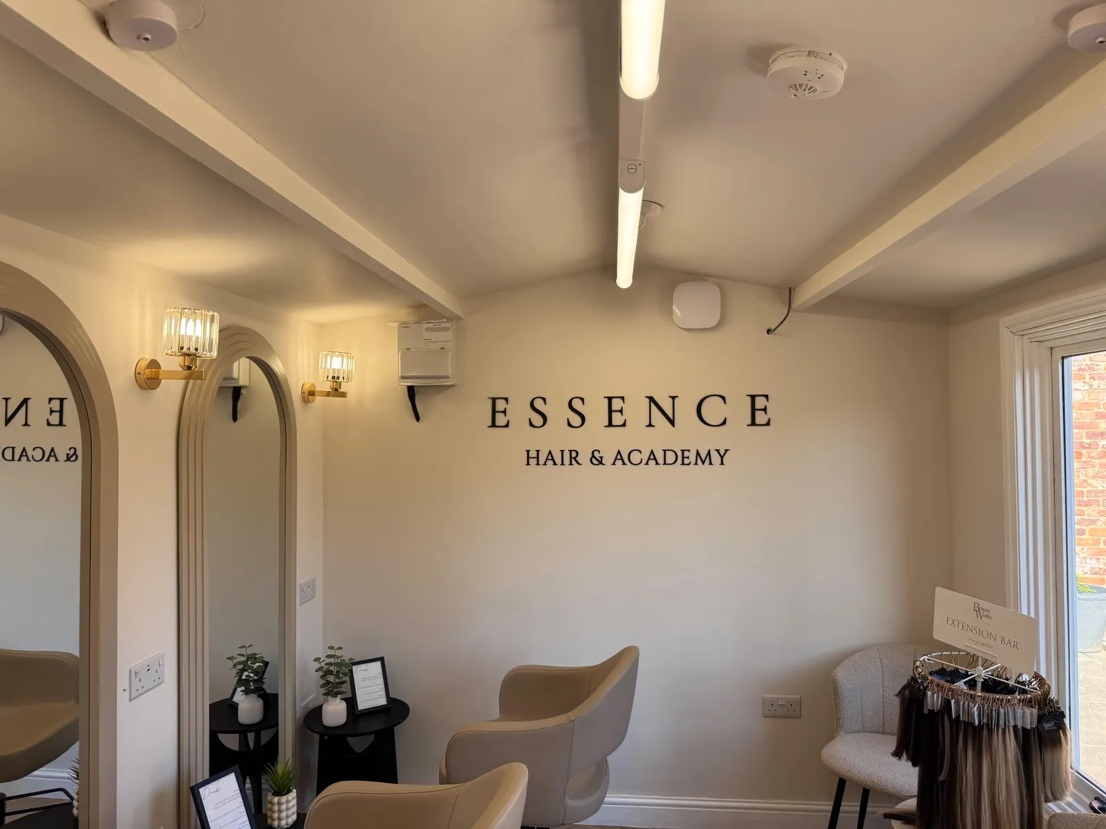 Inside the Essence Hair & Academy salon in Luton, with arched mirrors and styling chairs